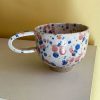 Splash keramikkop med hank fra Stenkvist Keramik. Koppen kommer i rustikt ler med lyserød og blå splash.