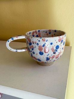 Splash keramikkop med hank fra Stenkvist Keramik. Koppen kommer i rustikt ler med lyserød og blå splash.