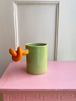 Lysegrøn keramikkop med knudehank i orange. Koppen er håndlavet i Tyrkiet hos Zoks Studio.
