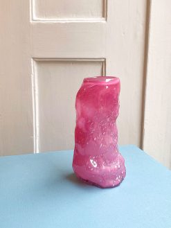 Mundblæst glasvase i magenta farvet glas med organiske former fra Marie Retpen. Vasen er mundblæst i Odense på Fyn.
