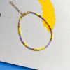 perlearmbånd fra Lulo Jewelry I lilla og gul med forgyldt lukning og kædeforlænger