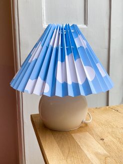 Light blue lampshade with white clouds. The lampshade is from Shady Business who produces and folds their products in Denmark from environmentally friendly paper.