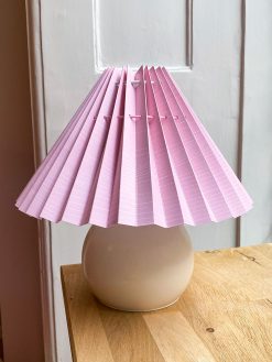 Pink lampshade with thin stripes . The lampshade is from Shady Business who produces and folds their products in Denmark from environmentally friendly paper.