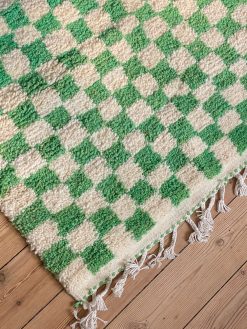 Checkered rug from Morocco. The rug is handmade and comes with green and white cubes and is made of 100% wool.