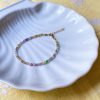 Perlearmbånd fra Lulo Jewelry med smykke perler i forskellige farver og med forgyldt lås og kæde forlænger. Armbåndet er håndlavet i Sønderjylland.