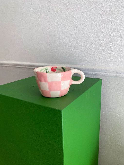 Ternet kop med hank og røde kirsebær nede i koppen. Håndlavet af Posy Ceramics.